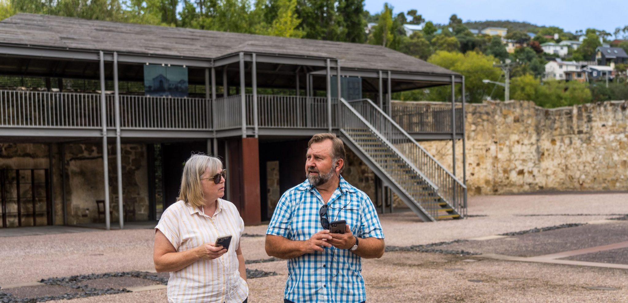A man and a woman listen to the audio experience in yard 1 | Cascades Female Factory | Historic Site Australia